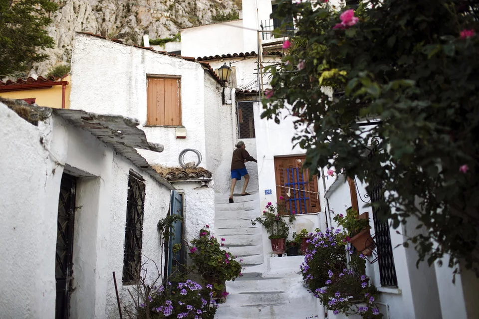 Ένας άνδρας ανεβαίνει τα σκαλιά στην παλιά συνοικία Αναφιώτικα της Αθήνας κάτω από τον αρχαίο λόφο της Ακρόπολης